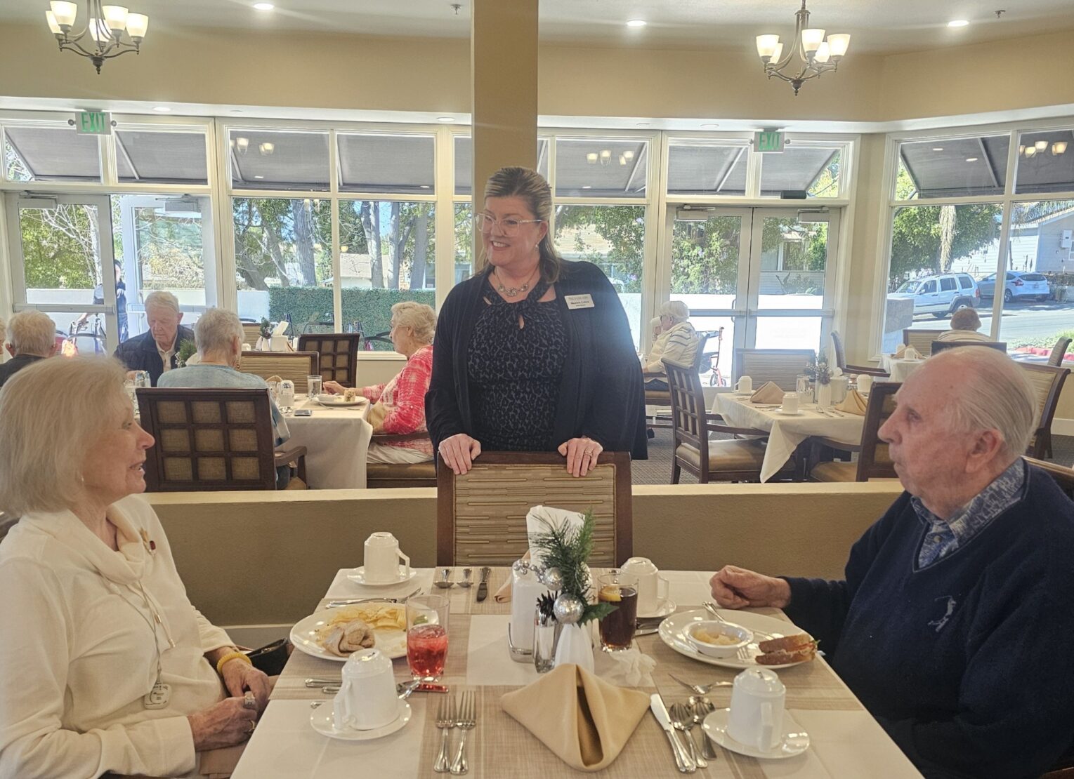 Maurene speaks with residents in the dining room